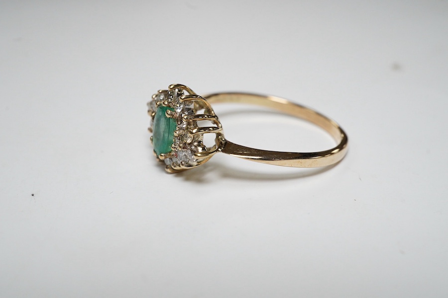 A yellow metal, emerald and diamond cluster set navette shaped ring, size P, gross weight 2.3 grams. Condition - fair to good